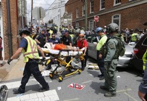 Rescue personnel help injured people after a car ran into a large group of protesters after a white supremacist rally in Charlottesville, VA