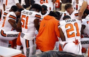 Members of the Cleveland Browns kneel during the national anthem