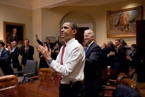 President Barack Obama, Vice President Joe Biden, and senior staff applaud in the Roosevelt Room of the White House, as the House passes the health care reform bill, March 21, 2010. 