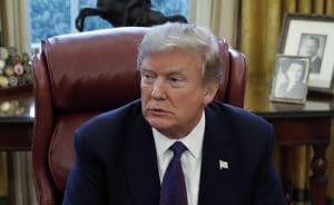 President Donald Trump sits at the Resolute Desk after signing Section 201actions in the Oval Office of the White House in Washington, Tuesday, Jan. 23, 2018.