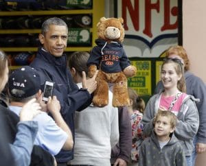 President Barack Obama holds up a stuffed bear that New Jersey Gov. Chris Christie, not shown, had won tossing a football after playing the 'Touchdown Fever' game on the boardwalk