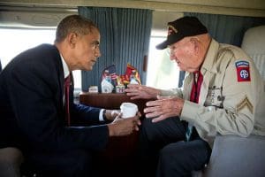 President Barack Obama talks with WWII veteran Kenneth (Rock) Merritt aboard Marine One after departing the 70th French-American Commemoration D-Day Ceremony at the Normandy American Cemetery and Memorial in Colleville-sur-Mer, France, June 6, 2014.