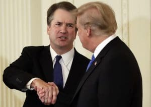 Kavanaugh shakes hands with Trump.