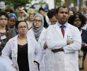 Hospital employees and others attend an anti-gun violence rally in front of the Bronx Lebanon Hospital Center in New York, Thursday, July 6, 2017. Dr. Tracy Sin-Yee Tam was fatally shot when Dr. Henry Bello opened fire at the hospital on June 30.