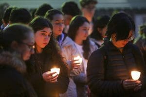 Students hold candles at a vigil.