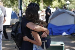 Couple hugging at a homeless camp.