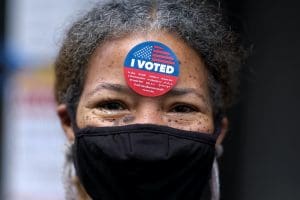 Woman with I Voted sticker on forehead