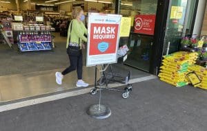 Grocery store mask sign and shopper