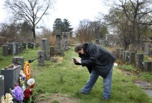 Son photographs his father's grave (COVID)