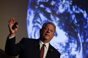 Al Gore, standing in front of a graphic projection of Earth, speaks while delivering a keynote presentation at the Climate Change Porto Summit in Portugal in 2019.