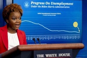 A graph titled "Progress on Unemployment" is displayed on a monitor behind White House deputy press secretary Karine Jean-Pierre as she speaks at a press briefing at the White House in Washington, Thursday, Nov. 4, 2021. (AP Photo/Andrew Harnik)