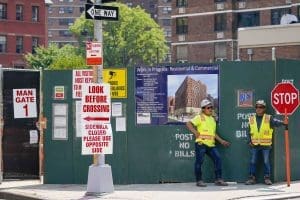 Construction workers help direct traffic outside a residential and commercial building under construction at the Essex Crossing development on the Lower East Side of Manhattan, Thursday, Aug. 4, 2022.
