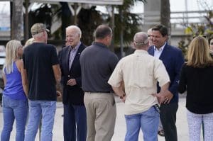 President Joe Biden and Florida Gov. Ron DeSantis talk with people impacted by Hurricane Ian on Wednesday, Oct. 5, 2022, in Fort Myers Beach, Fla. (AP Photo/Evan Vucci)
