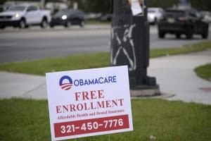 A sign advertises free enrollment for Obamacare health insurance alongside a road on Jan. 4, 2023, in Orlando, Fla.