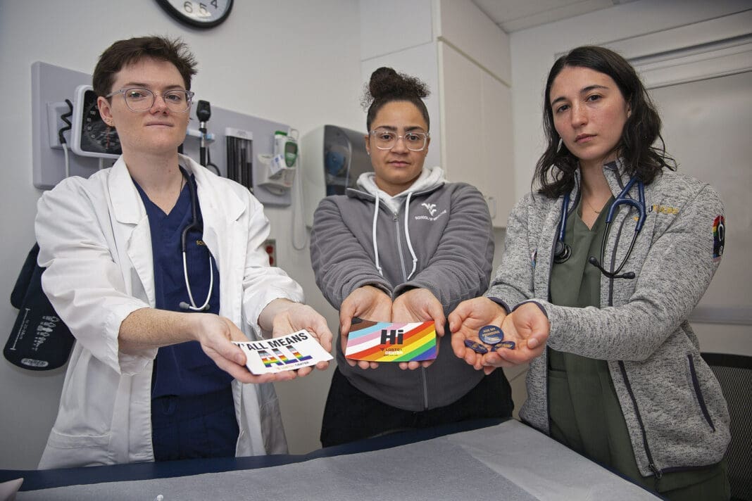 West Virginia University students El Didden, Bri Caison and Lia Farrell hold materials from the Rainbow Coats on Wednesday, March 8, 2023, in Morgantown, W.Va.