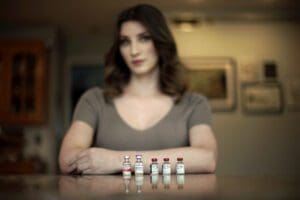 Stacy Cay displays some of the hormone therapy drugs she has stockpiled, Thursday, April 20, 2023, at her home in Overland Park, Kansas