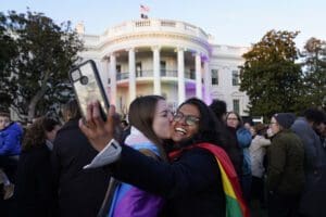 Aparna Shrivastava, right, takes a photo as her partner Shelby Teeter gives her a kiss, after President Joe Biden signed the Respect for Marriage Act, Tuesday, Dec. 13, 2022, on the South Lawn of the White House in Washington.