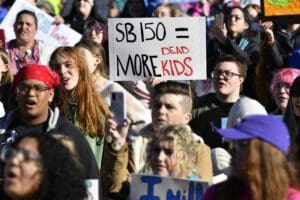 A protester holds up a sign saying "SB 150 = more dead children" during a rally against Senate bill SB150, known as the Transgender Health Bill, in on the lawn of the Kentucky State Capitol in Frankfort, Ky., Wednesday, March 29, 2023.