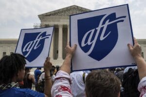 Members of the American Federation of Teachers (AFT) hold up signs with the union's logo outside the Supreme Court in Washington, D.C. on June 30, 2023. (Photo by Alejandro Alvarez/Sipa USA)(Sipa via AP Images)
